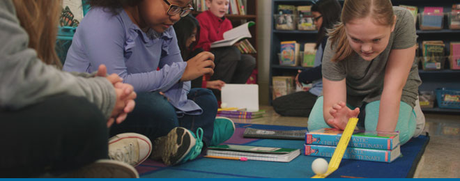 students using a ping pong ball in a classroom experiment