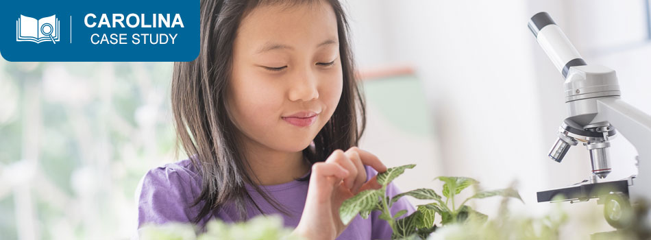 young girl viewing plants with a microscope
