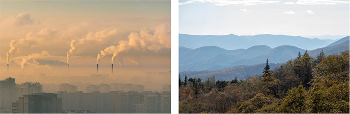 factory bellowing smoke and clear moutain range